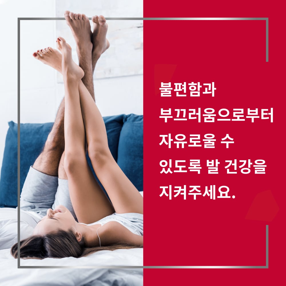 Couple lying on bed with crossed legs up and smiling